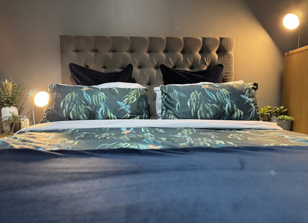 Simba Review Hybrid Mattress Bedding made up bed in dark blue tones